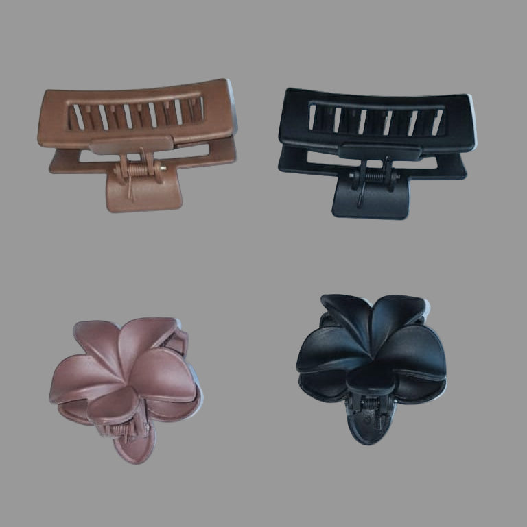 Two brown hair clips and two black hair clips on a white background