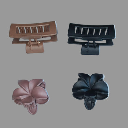 Two brown hair clips and two black hair clips on a white background