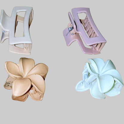 Four hair clips in different designs on a wooden surface